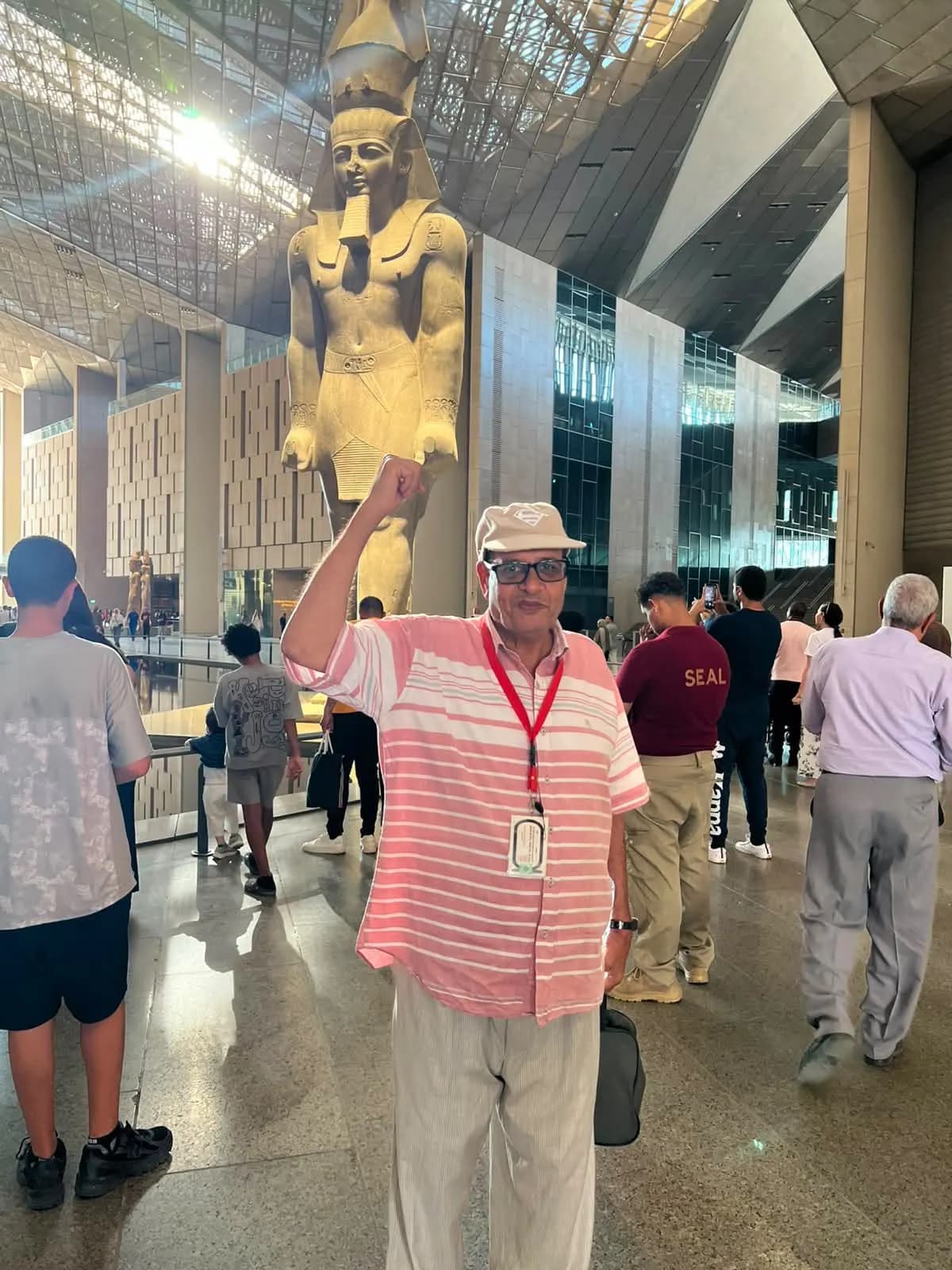 A traveler posing before the colossal Ramesses II statue at the Grand Egyptian Museum