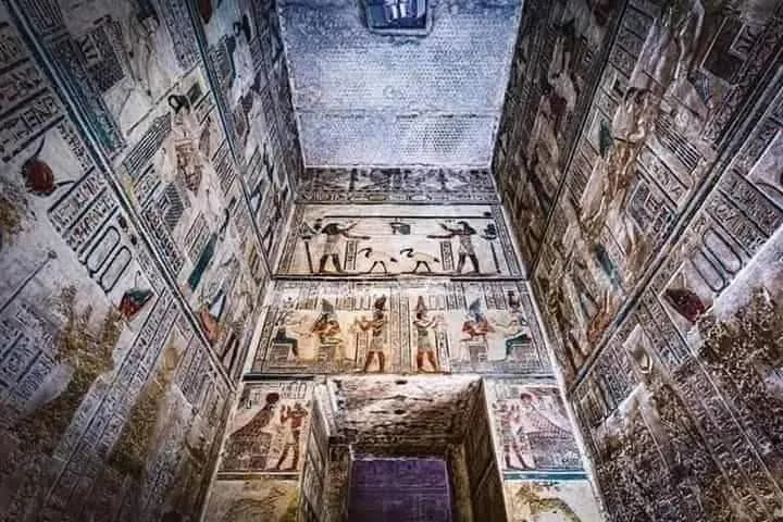 Colorful painted reliefs on the walls and ceiling of an ancient Egyptian temple