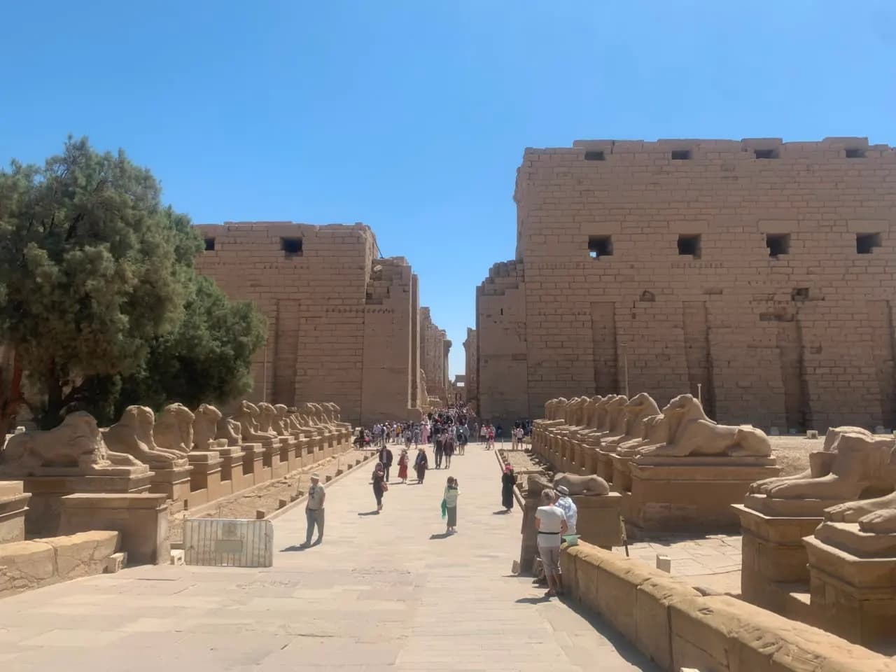 Tourists on the ram-sphinx avenue leading to Karnak Temple's first pylon, Luxor
