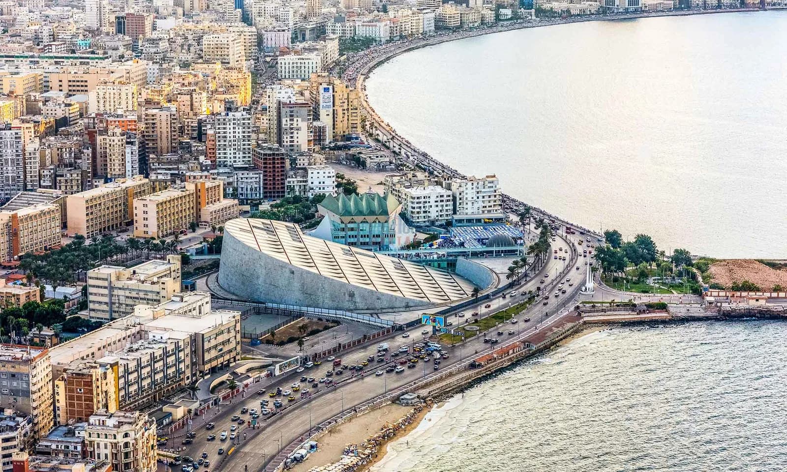 The Alexandria corniche curving along the Mediterranean toward the citadel at dawn.